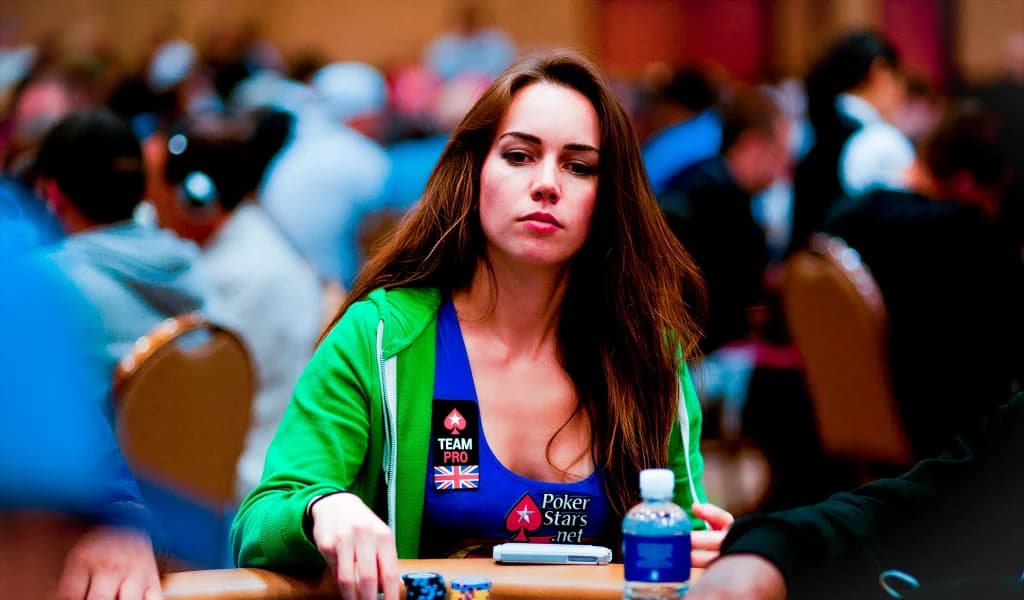Liv Boeree sits at a crowded poker tournament table, focused on the game.