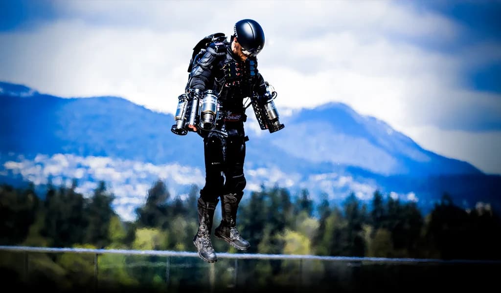 Richard Browning hovering in a jet suit above a mountainous landscape.