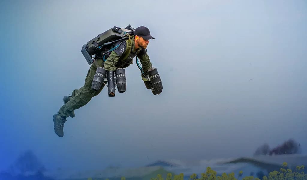 Richard Browning flying horizontally in a jet suit over a misty landscape.