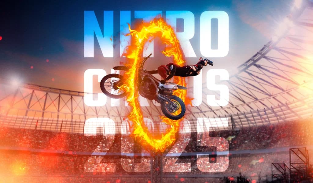 Motorcyclist jumps through a flaming ring at Nitro Circus 2025 in a packed stadium.