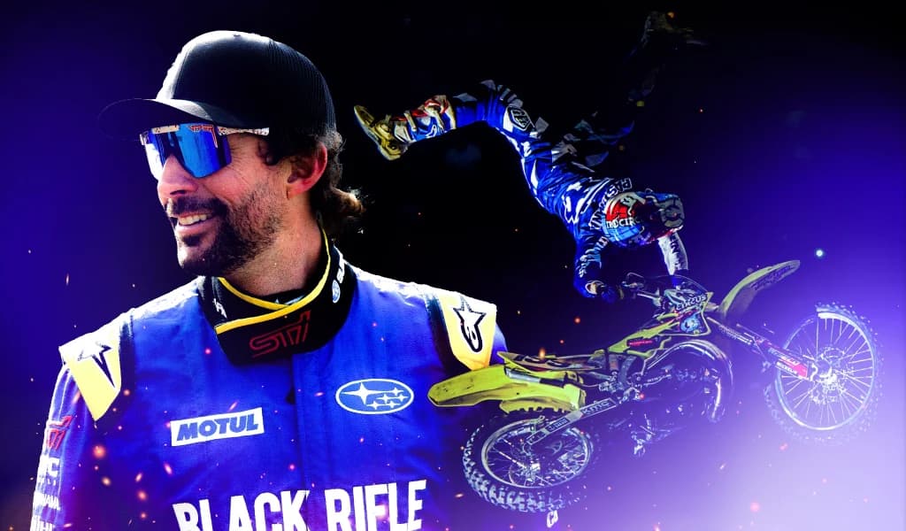 Man, Travis Pastrana, in racing gear smiling in profile, with a smaller overlay of him mid-air on a dirt bike against a dark background.