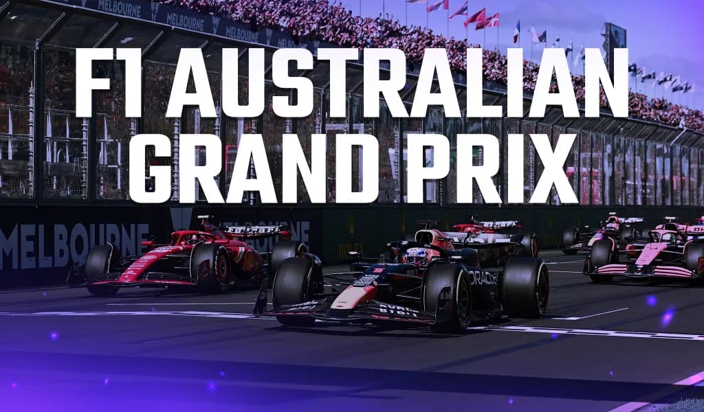 Formula One cars racing on the Melbourne track in front of grandstands full of spectators.