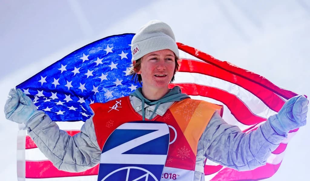 Red Gerard holding an American flag after an alpine skiing event at the Winter Olympics.